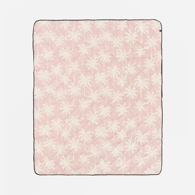 Pink blanket with white floral pattern on a light pink background