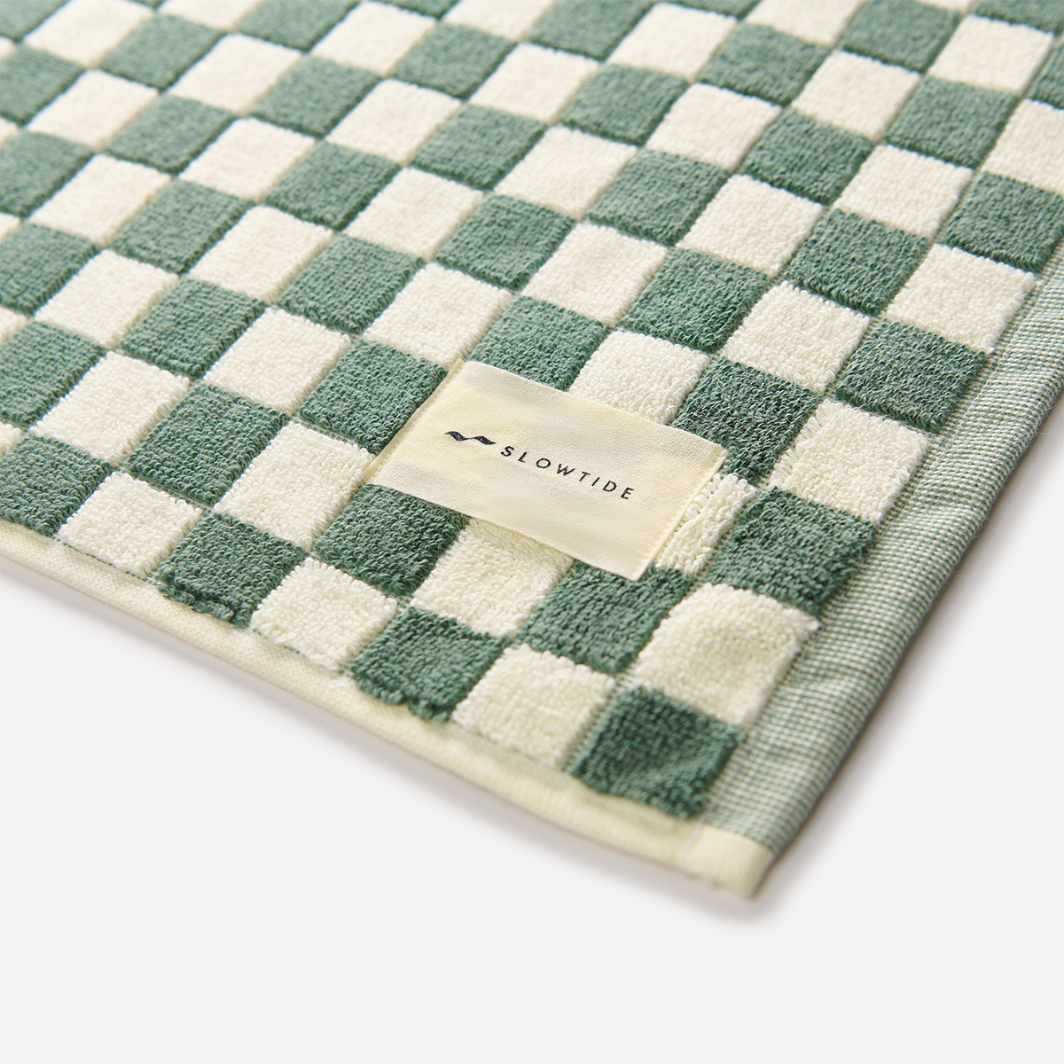 Bath mat with green and white checkerboard pattern.