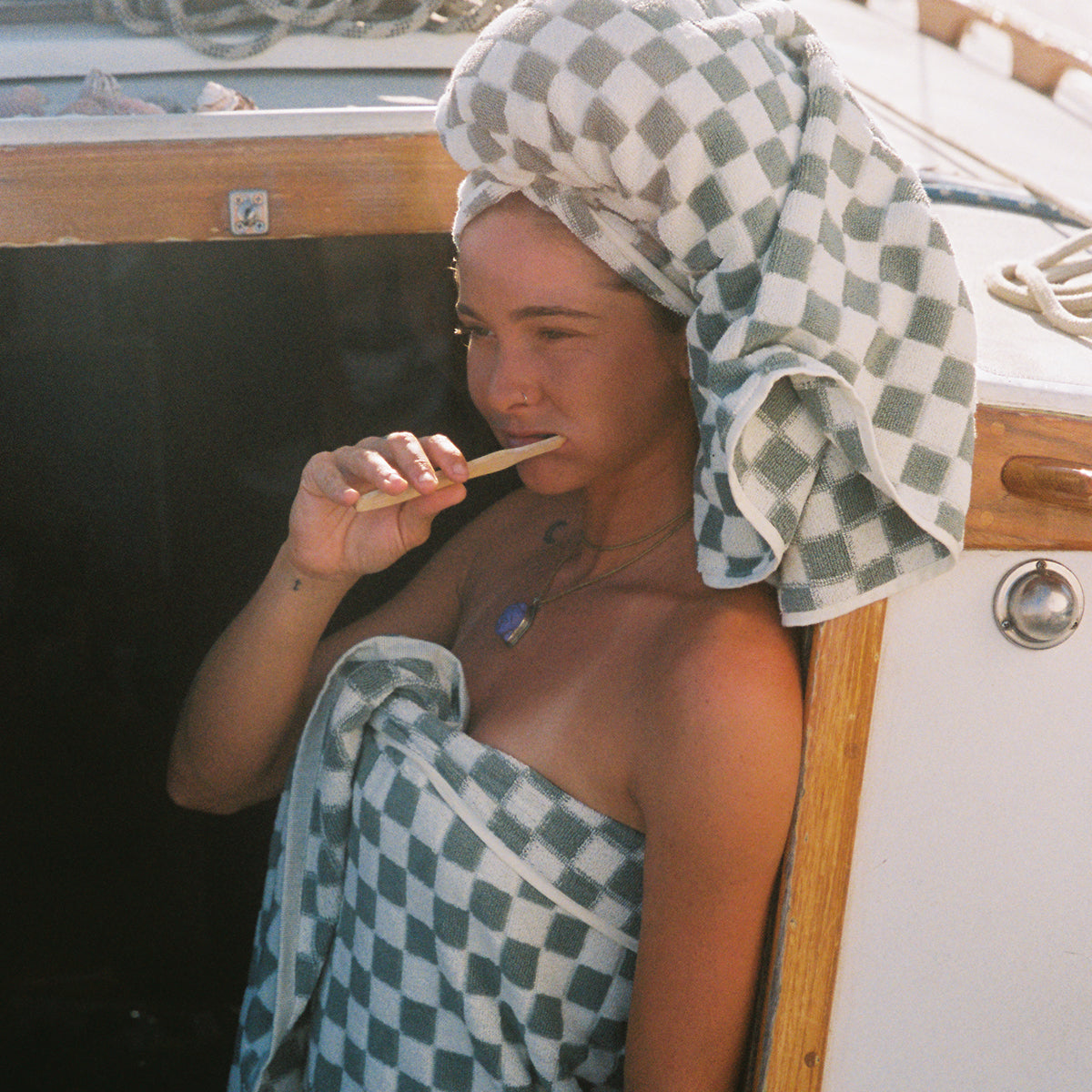 Checkered absorbent towel with wrap design shown in use on a boat.