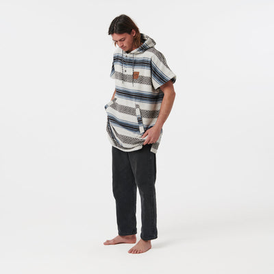 Striped cotton towel poncho with black pants, absorbent fabric.