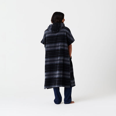 Striped hooded surf poncho with dark pants shown on barefoot model.