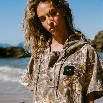 Poncho with camouflage pattern in outdoor beach setting.