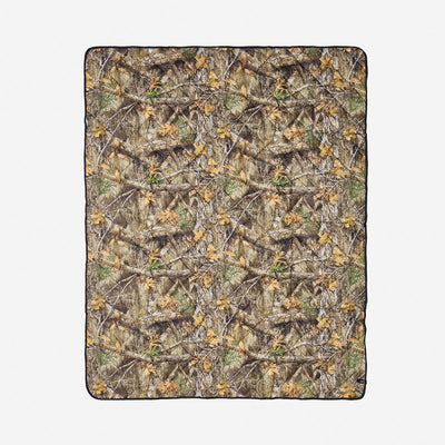 Quilted packable blanket with photorealistic camo print on white background.