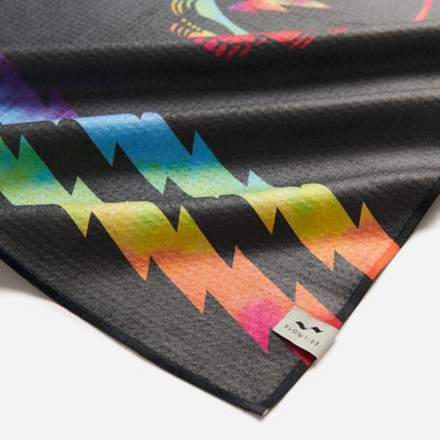 Kitchen towel with rainbow lightning bolt pattern and tag on corner.