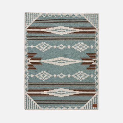 Geometric area rug with blue, brown, and white diamond pattern.