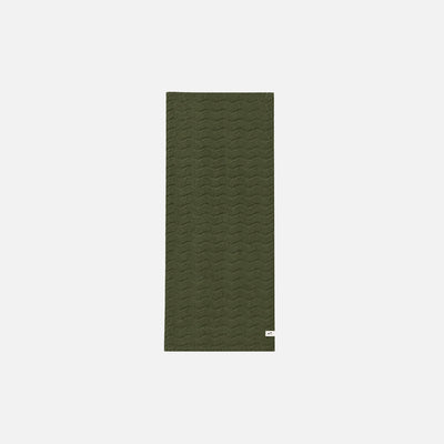 Cotton towel in olive green with wavy pattern on white background.