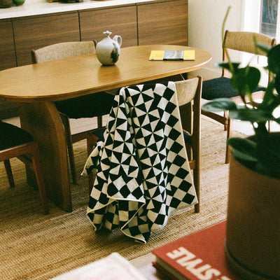 Cotton geometric-patterned blanket, 600 GSM, displayed over a dining chair.