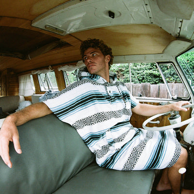 Striped towel poncho with hood, absorbent cotton, shown inside a vintage van.