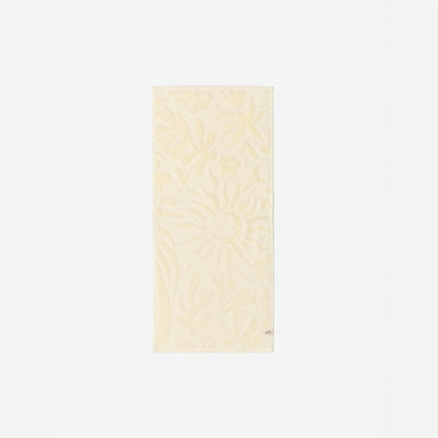 Cream cotton towel with sculpted floral and raised sun pattern, 550 GSM, for bath use.
