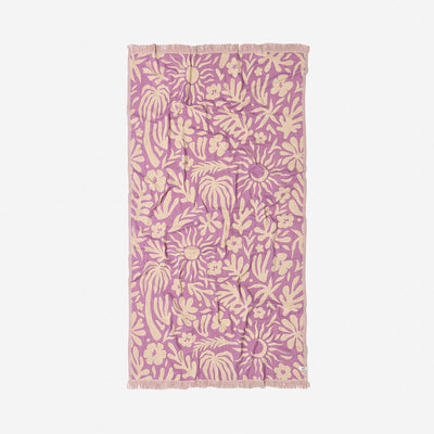 Towel with beige botanical print and fringe edges on white fabric.