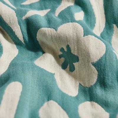 Turkish towel, lightweight cotton, teal with white floral pattern, close-up of texture.