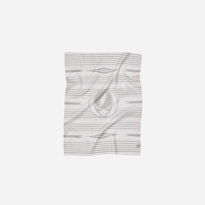 Kitchen towel with gray and white geometric patterns and skull logo.