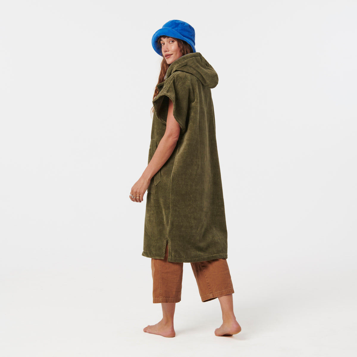 Green towel poncho, blue hat, and brown cropped pants displayed together.