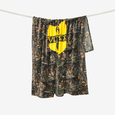Fleece throw with camouflage pattern and yellow shield logo on a white clothesline.