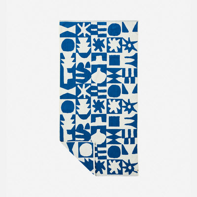 Bath towel in high-density cotton with bold blue and white geometric pattern.