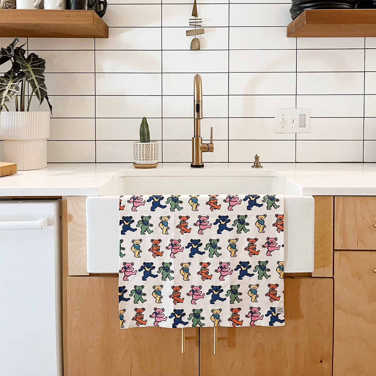 Kitchen towel with Dancing Bears pattern, quick-dry fabric, hanging on white farmhouse sink.