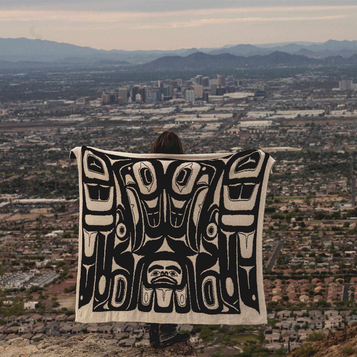 Tlingit blanket with Eagle pattern, woven textile displayed outdoors.