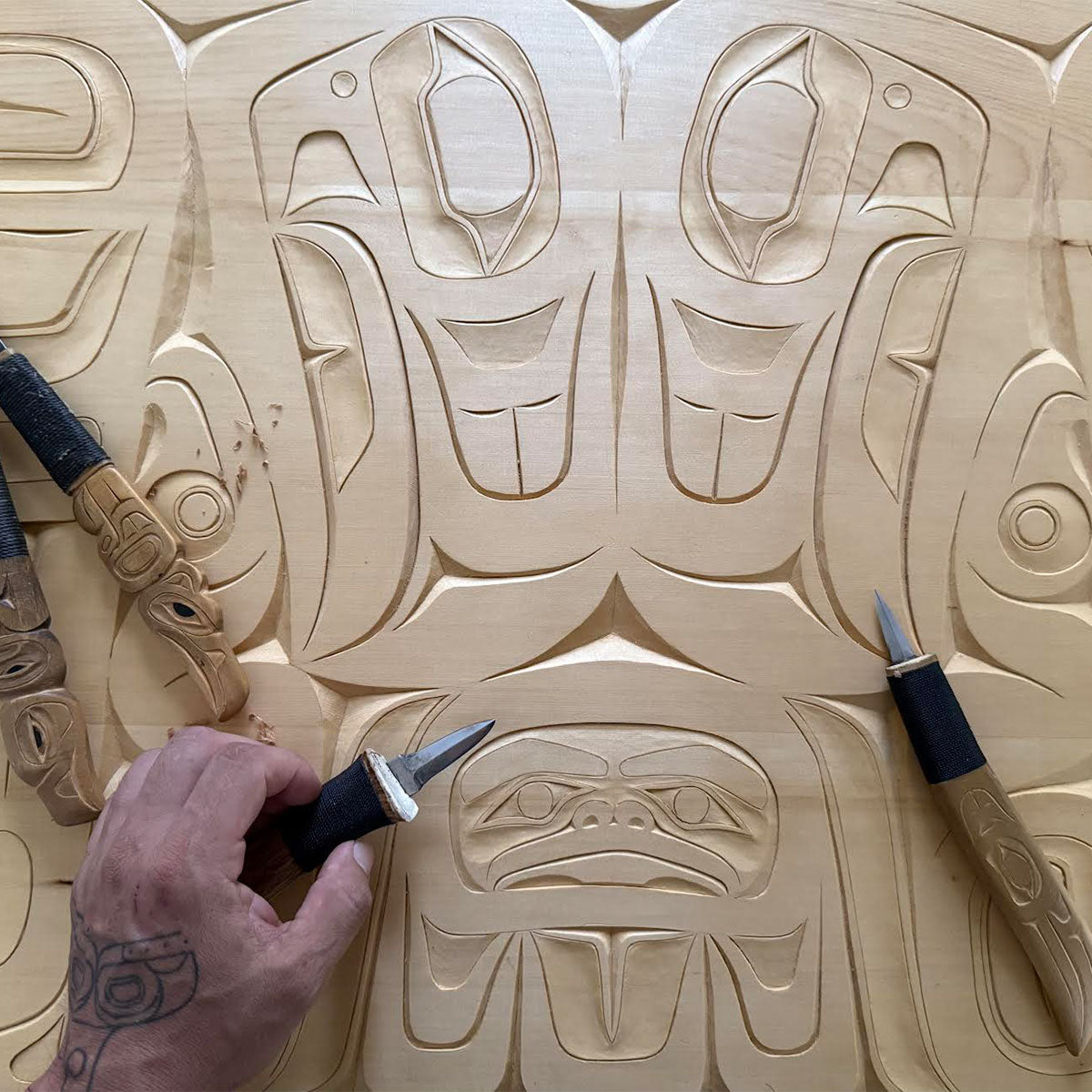 Wood decor piece with intricate Indigenous patterns, detailed like woven kitchen towels.