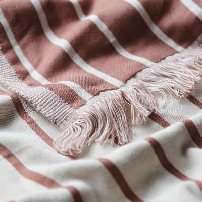Reversible fabric with earthy tones and terracotta stripes, lightweight texture shown up close.