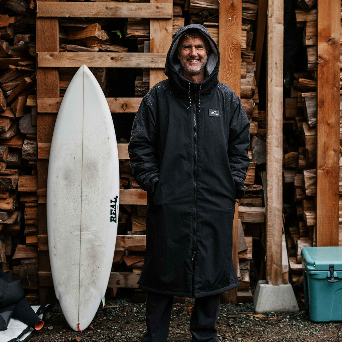 Black insulated parka with hood, displayed outdoors.