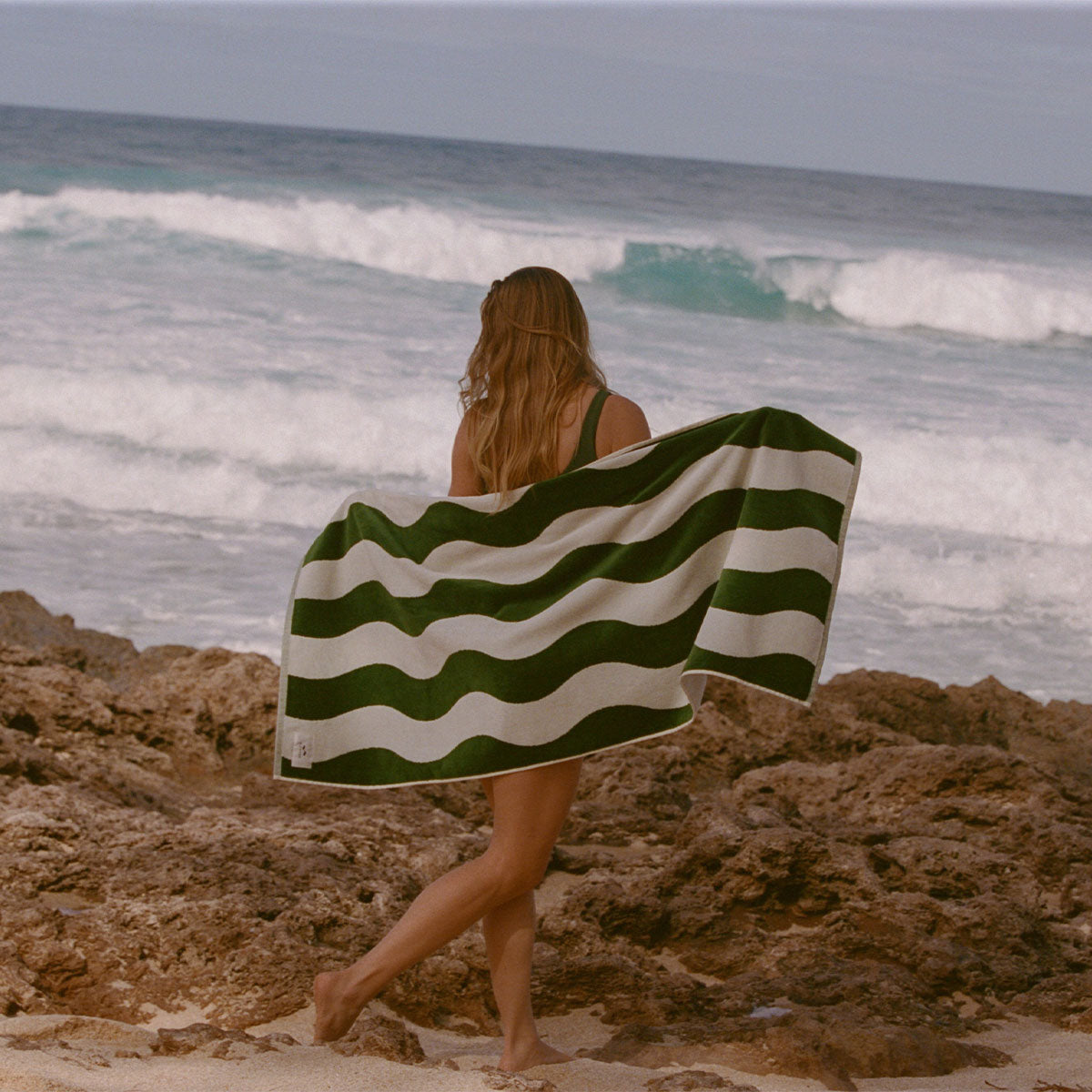 Beach towel in absorbent green and white wavy-striped velour.