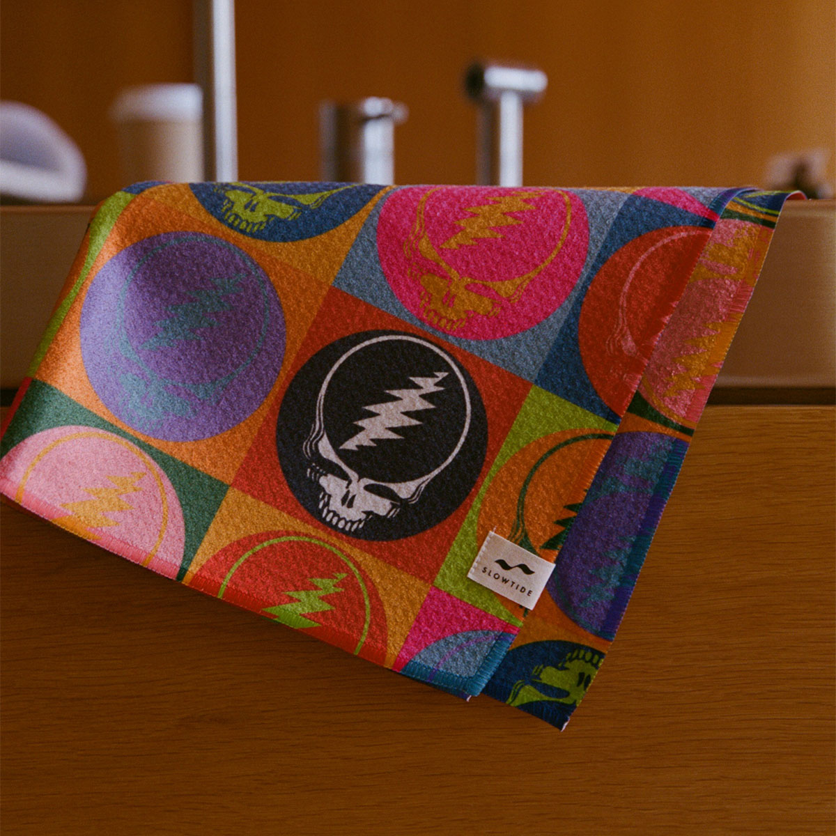 Quick-dry kitchen towel with colorful skull graphic on a wooden surface.