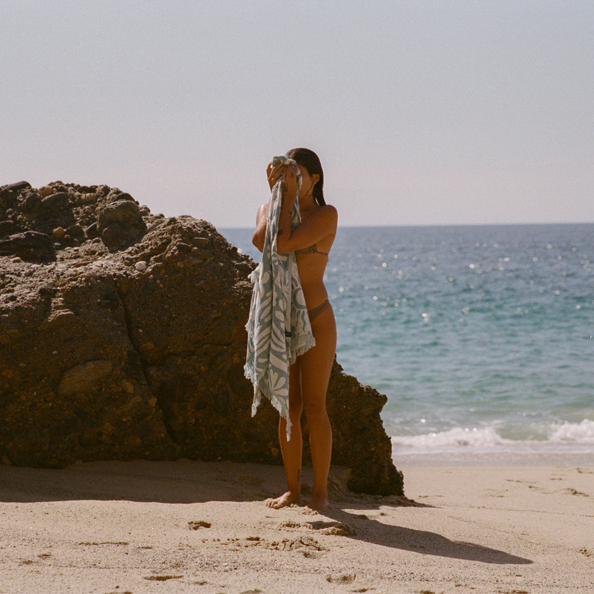 Turkish towel, lightweight cotton, natural color, beach setting.