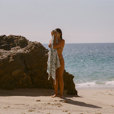 Turkish towel, lightweight cotton, natural color, beach setting.